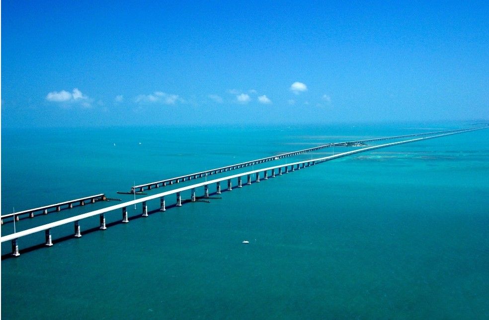 An aerial view of the Seven Mile Bridge stretching across blue water in the Florida Keys.